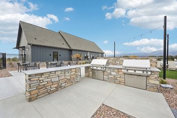 A house with a stone wall and a garage.at The Garrison Luxury Apartment Homes, Fountain Colorado